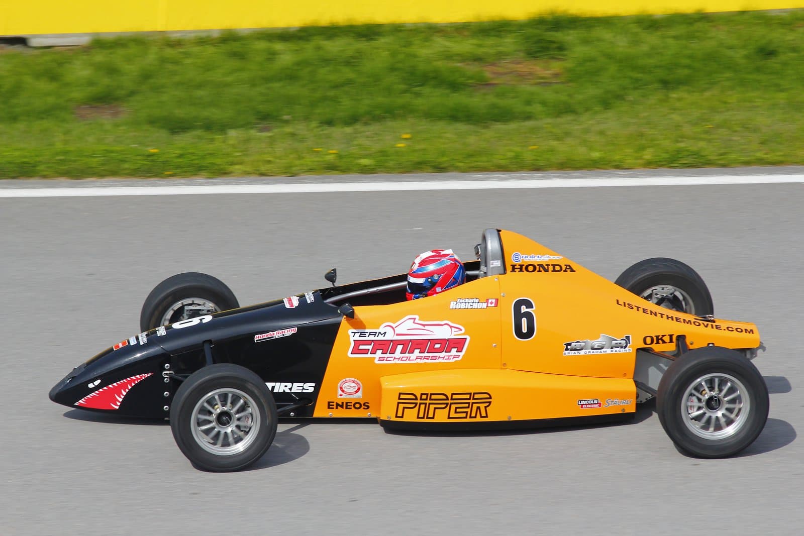 An open-wheel formula race car on track, seen side-on