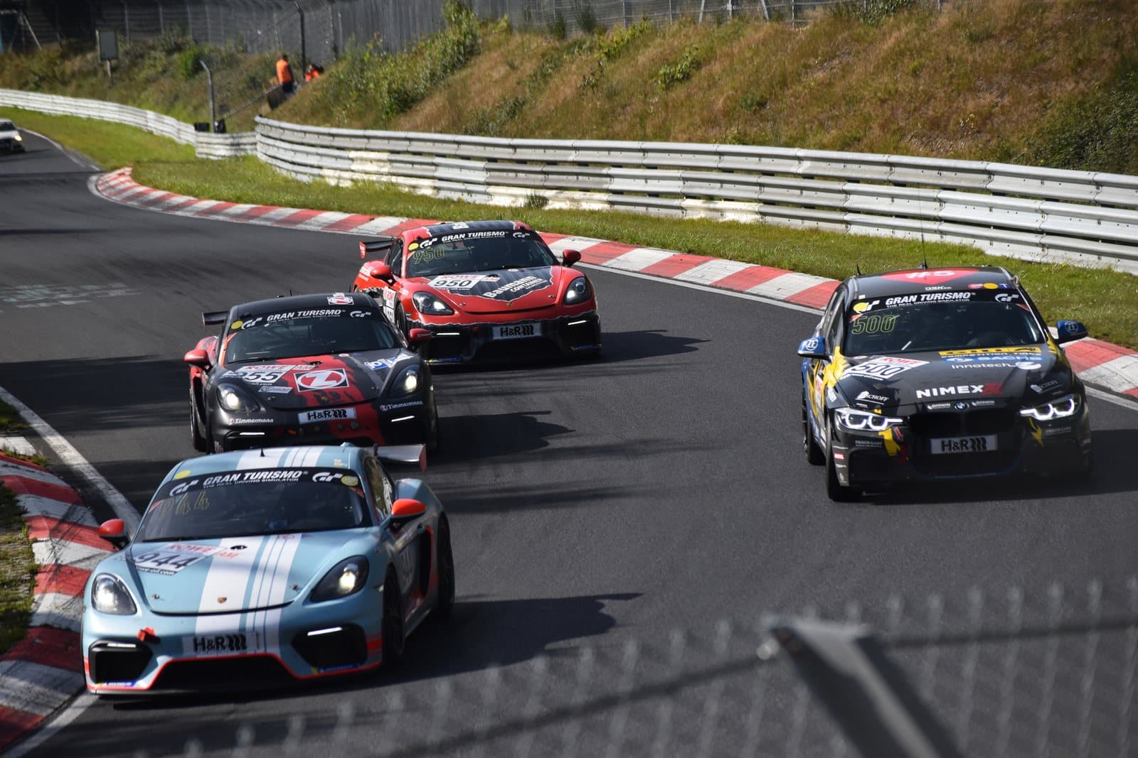 A group of sports cars racing through a corner on a track