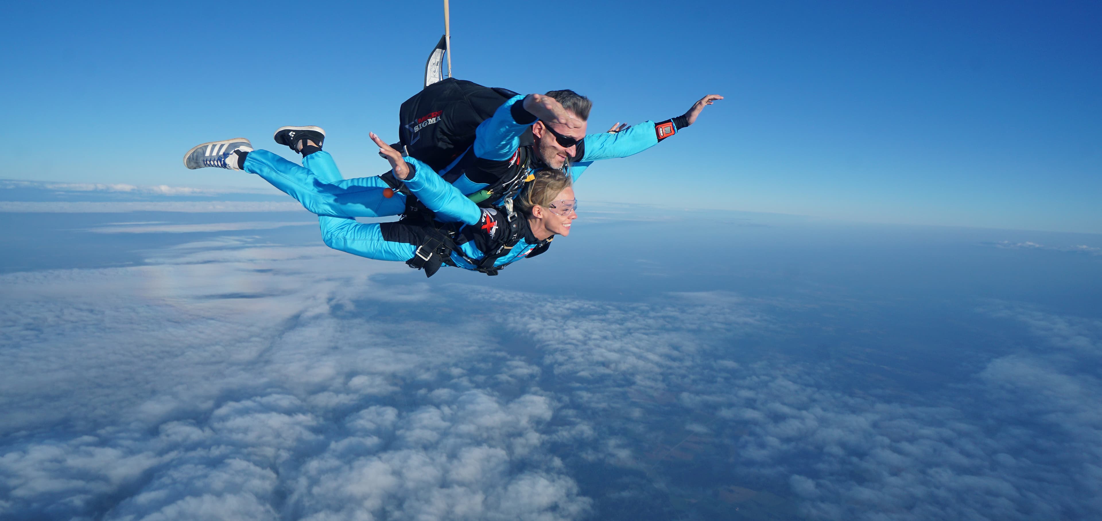 Tandem pair in blue suits in freefall