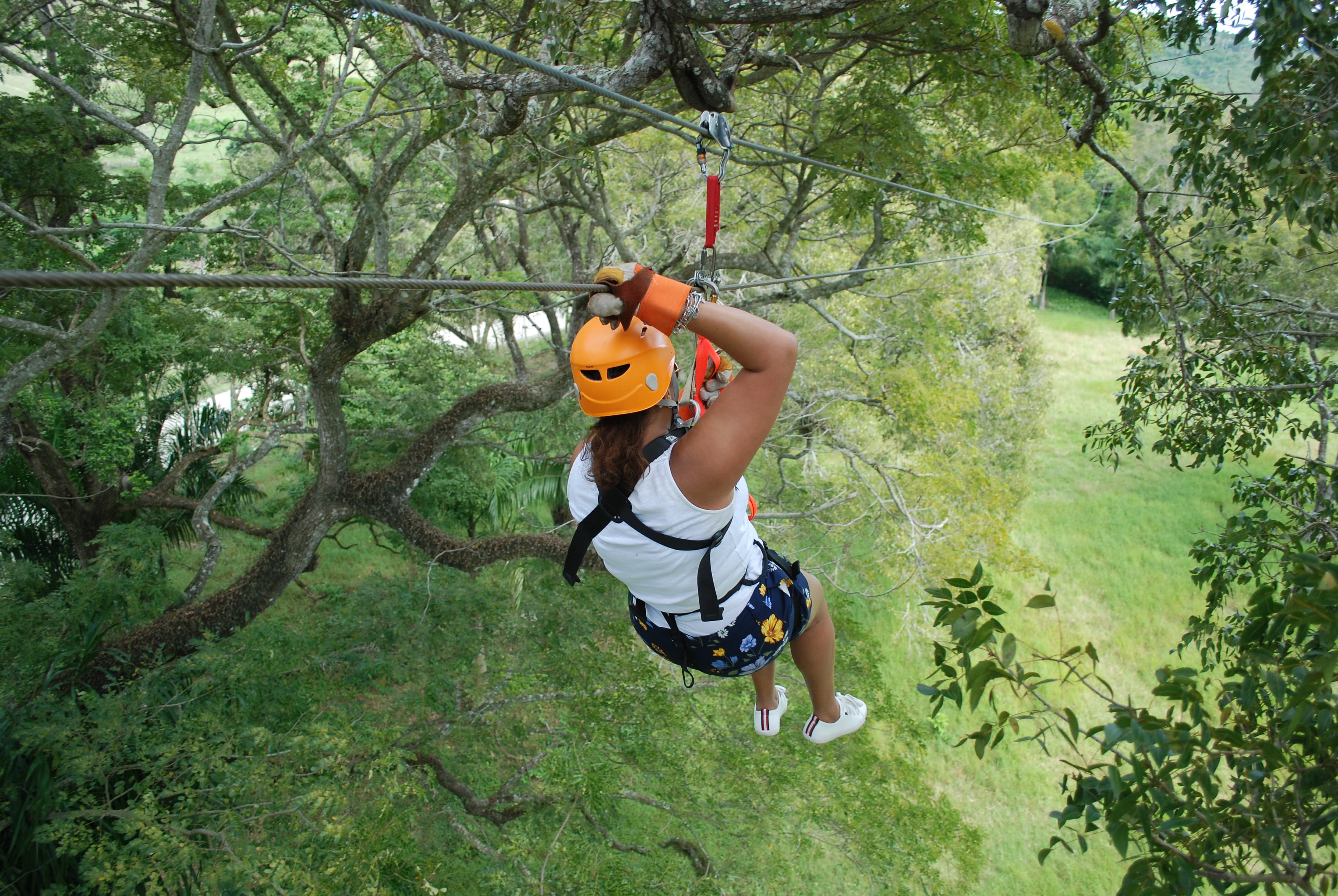 Person on a zipline, helmet and shoes visible